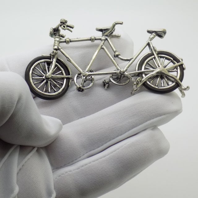 This vintage silver figurative sculpture depicts a tandem bicycle, crafted as a desktop novelty, cabinet curiosity, or...