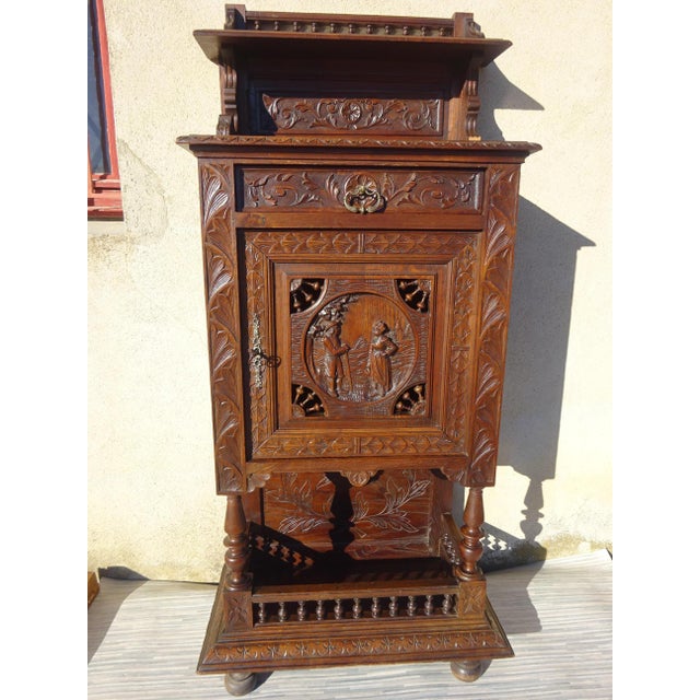 Small storage cabinet, finely hand-carved French. Originating from Brittany, depicting a scene of daily life in bas-...