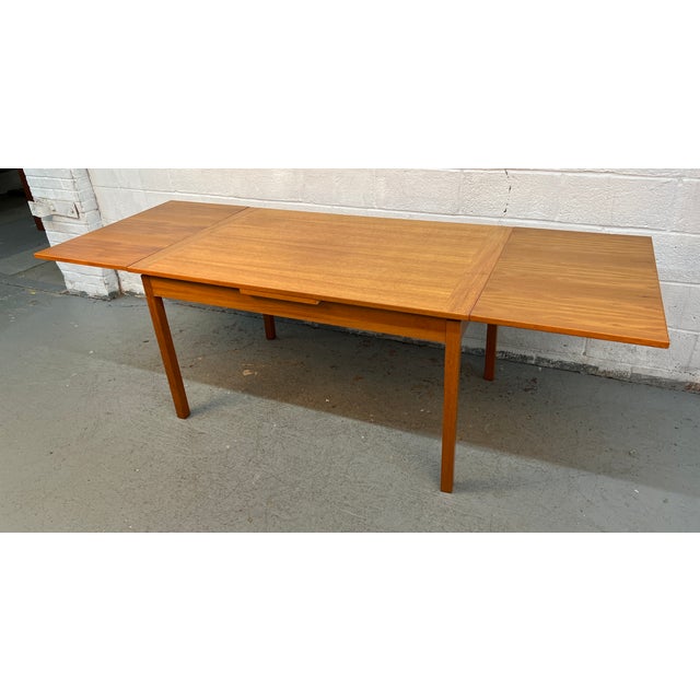 This Mid-century modern Danish teak dining table features two sliding draw-leaf extensions for versatile seating. Open...