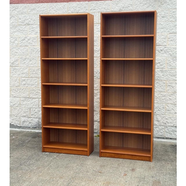 Impressive pair of vintage Mid-Century Modern bookcases with warm, richly grained wood veneers and clean architectural...