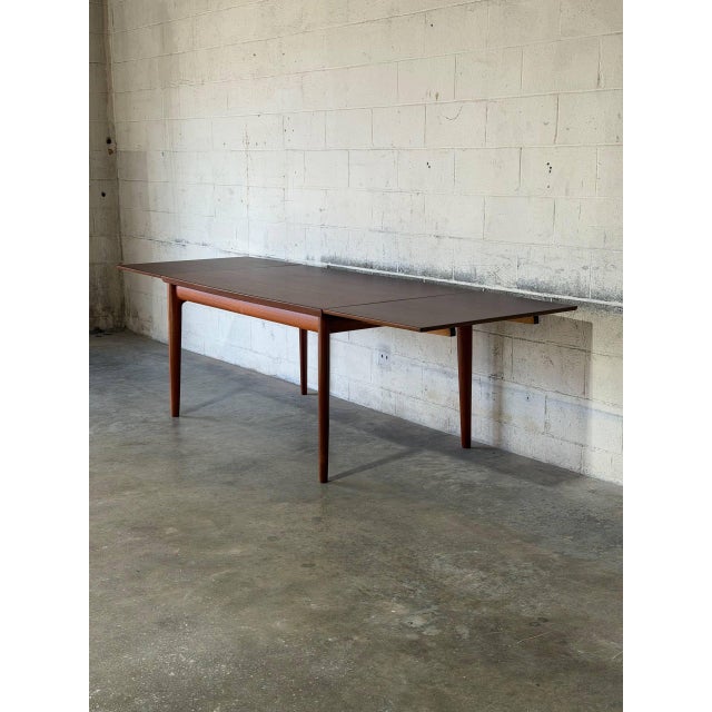 This elegant dining table features a streamlined silhouette and subtly tapered legs. Its clever design incorporates two...