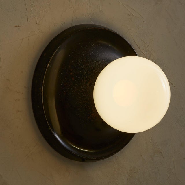 Sold and priced individually. Achille Castiglioni’s ‘Light Ball’ sconce for Flos, designed in 1965, is a study in pure...