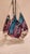 This listing features an abstract tear drop shaped glass sculpture with purple, pink, and blue abstract glass pieces...