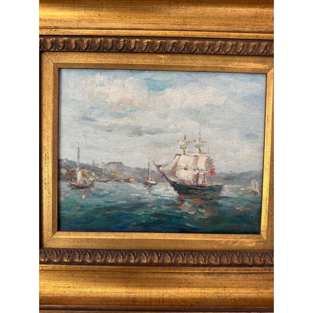 A charming small-scale oil painting depicting a serene harbor scene with sailboats gliding across gently textured blue...