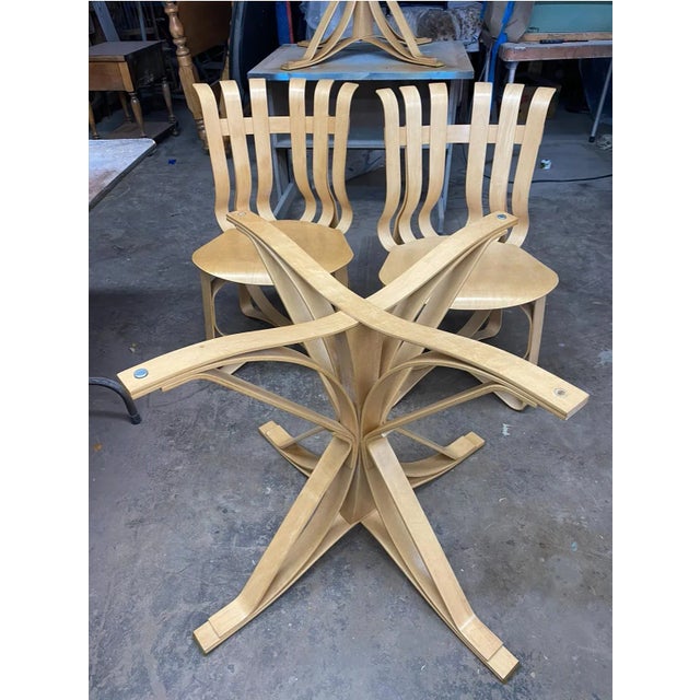 6 Hat Trick Chairs + 2 Face Off Table Bases with Glass Table Top. Stamped with Frank Gehry Signature and Dated. The pieces...