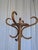 Vintage bentwood coat stand featuring elegantly curved hooks and a sculptural bentwood base with circular support. A...