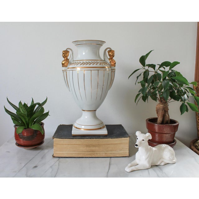 Vintage Neoclassical porcelain white and gold urn with female figural handles. No makers mark. Hairline crack. Pictured.