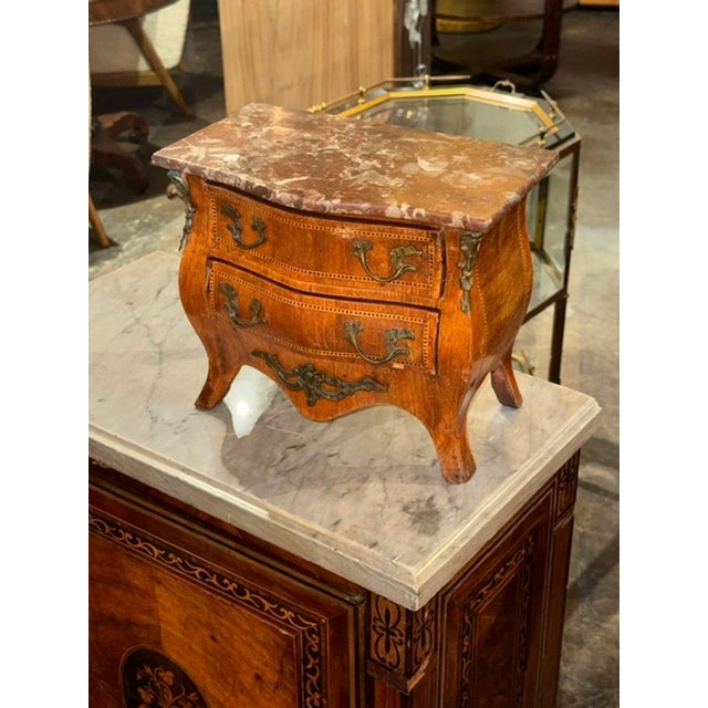 The product is a 19th-century French Louis XV miniature walnut commode. This piece is a decorative collectible item during...