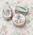This set of three vintage trinket boxes combines delicate hand-painted porcelain with detailed silverplate casings, each...