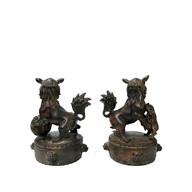 This stunning pair of antique Chinese Foo Dog (or guardian lion) sculptures is meticulously cast and detailed with a rich...