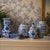 A striking 14-inch vintage blue and white porcelain vase featuring lush floral motifs in saturated cobalt glaze. The...