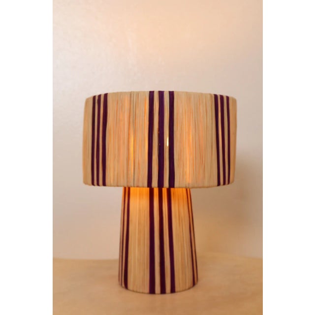Purple and natural striped raffia table lamp Discover our handmade boho, purple-striped raffia table lamp, the perfect...