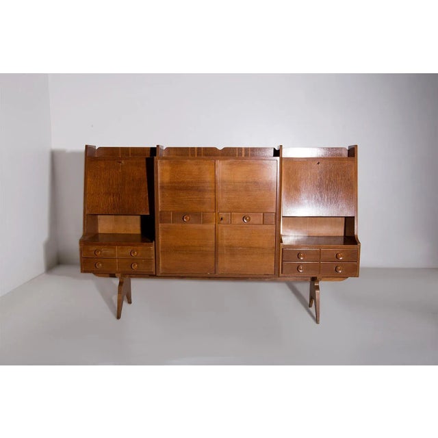 This tall wooden cabinet from the 1950s, crafted by the renowned artisans of the Associazione Artigiani Canturini del...