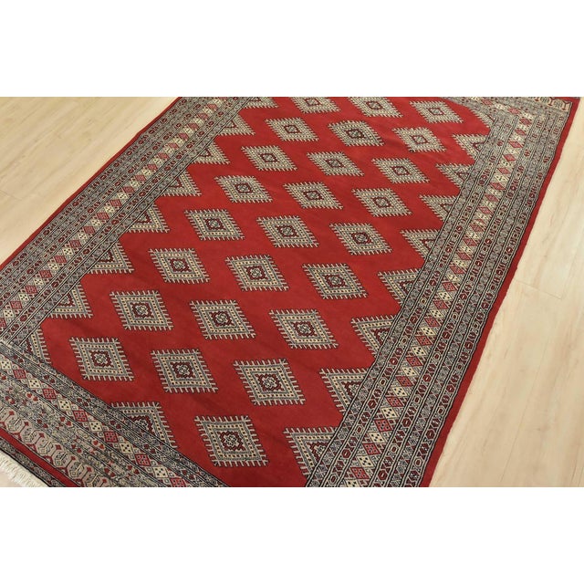 A tribal Bokhara Jaldar rug hand-knotted with fine wool on a cotton foundation. This rug features rows of repeating...