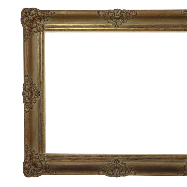 Large, dark, gold-toned pine frame featuring a beautiful aged patina; designed in a classic Baroque style and adorned with...