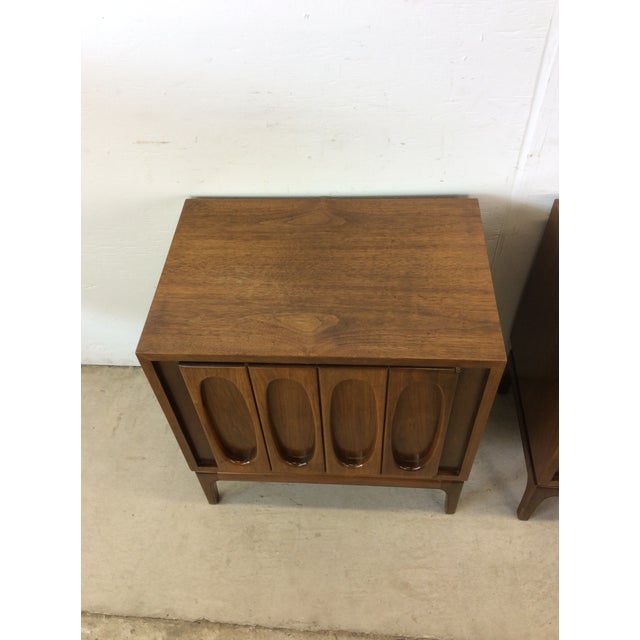 This pair of mid century modern nightstands feature hardwood construction, walnut veneer with original finish, cabinet...