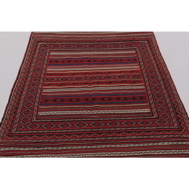 Made with handwoven wool circa 1950-1960, this 4x7 vintage Persian Kilim, originating from the Larkhabi region of...
