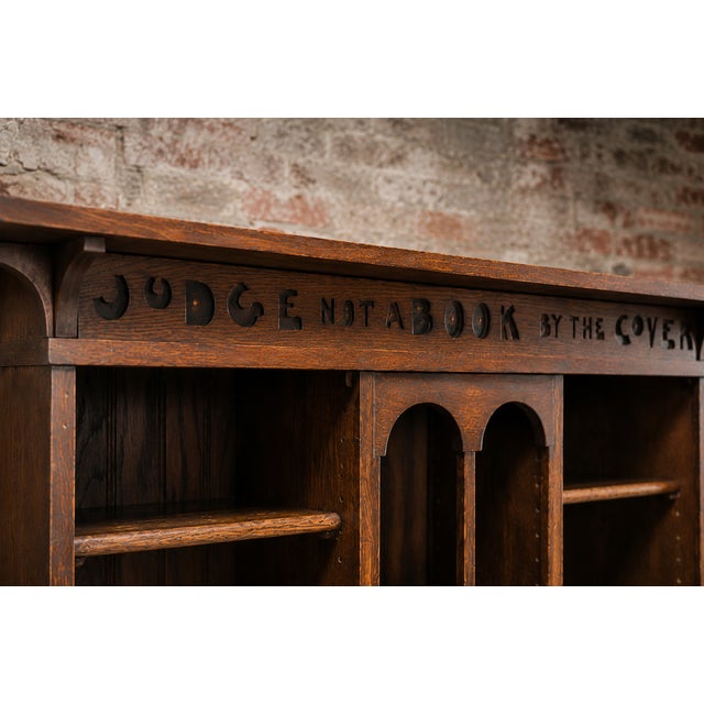 A wonderfully characterful english arts & crafts solid oak bookcase dating from around 1910, featuring the charming carved...