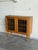 This compact oak cabinet presents a clean rectangular case on four tapered legs. Two leaded glass doors create a...