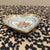 This exquisite heart-shaped porcelain dish captures the elegance of the French Neo-Classical period. The central medallion...