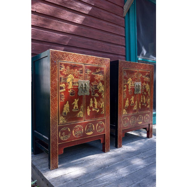 A rare matching pair of 19th-century Chinese red lacquer cabinets, beautifully decorated with hand-painted gilt scenes...