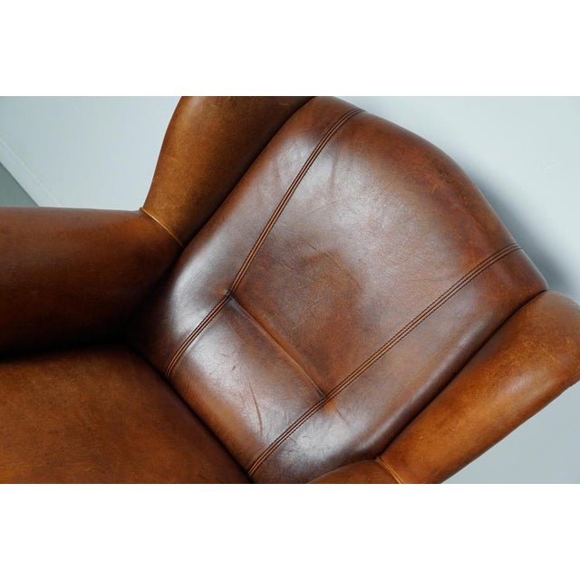 This cognac-colored leather club chair comes from the Netherlands. It is upholstered with cognac-colored leather and...
