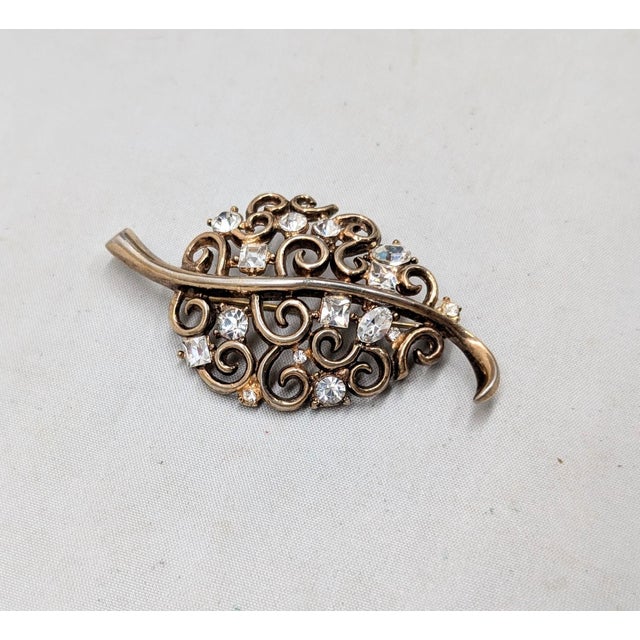 1949-50 goldtone openwork with curls leaf with clear round, square and oval rhinestones brooch with security clasp. Marked...
