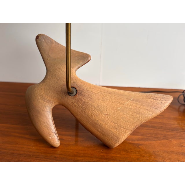 Dove Wood Carved Table Lamp with brass tube that has lamp socket at one end and wood ball at other end where the wire...