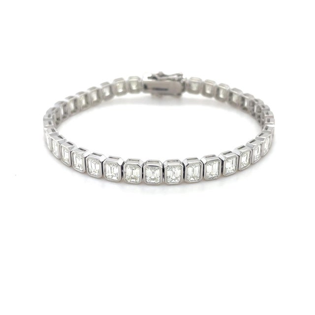 Classic with a twist, this bracelet contains 38 bezel set emerald cut diamonds weighing 12.50 carats total. Crafted in...