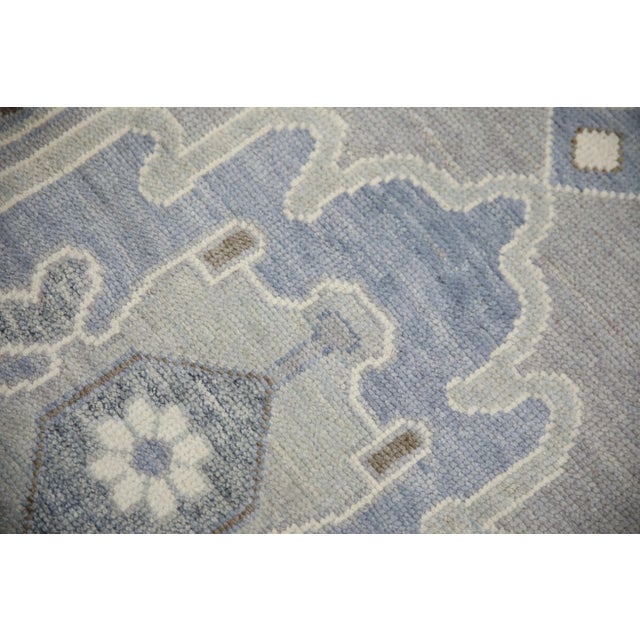 This modern Turkish Oushak rug is a stunning piece of art that has been handwoven using traditional techniques by skilled...