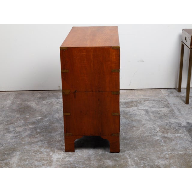 An English Campaign teak wood chest from the 19th century, with brass hardware and bracket feet. Created in England during...