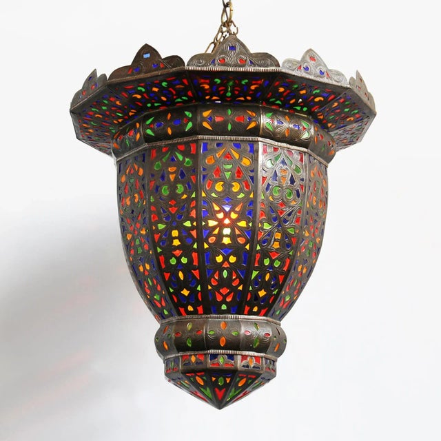 Vintage brass Moroccan lantern with inset inlay colored glass work. Top of lantern is open projecting light towards the...