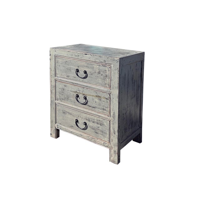This rustic nightstand embodies a timeless, weathered charm with its distressed, pale gray finish that reveals hints of...