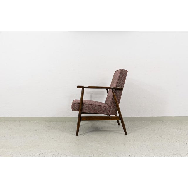 Pair of armchairs, produced in Radomsko, Poland, 1960s. The frames features turned legs, long rounded armrests – all made...