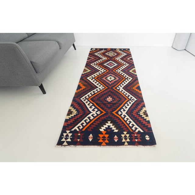 This is a vintage Turkish Oushak rug from the Mid 20th Century. The piece was hand-knotted.