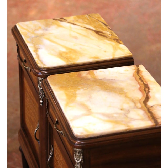 This elegant pair of antique French nightstands combines refined Louis XVI proportions with richly figured contrasting...