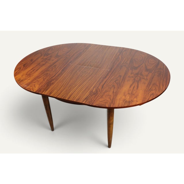 An elegant extendable dining table dating from the 1960s, characteristic of modernist furniture from that period. Its...