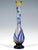 Solitary vase in the shape of a teardrop: a bulbous body resting on a stepped round base, tapering upwards and converging...