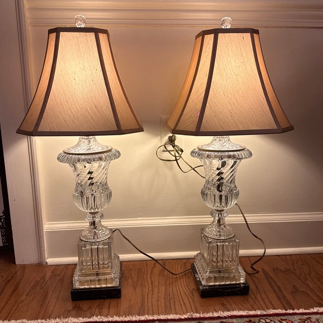 A wonderful pair of Baccarat style swirl crystal urn from lamps on black and white marble bases with gilt metal accents....
