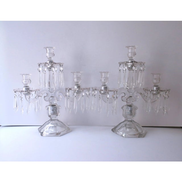 A beautiful pair of two arm, three light, transparent glass candelabras with crystal drop prisms and removable bobeches,...