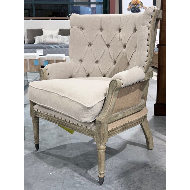 A beautifully tailored accent armchair by Sarreid, showcasing a tufted linen upholstered back and seat in a soft neutral...