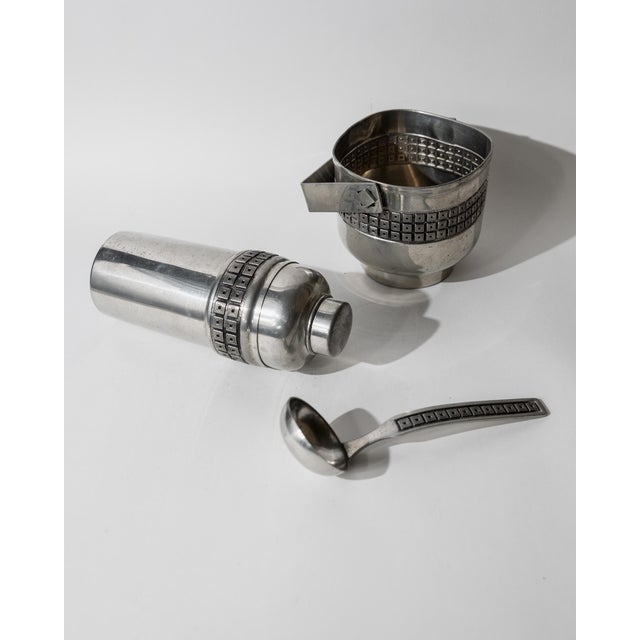 This vintage pewter cocktail set from the 1960s is a refined barware ensemble featuring a cocktail shaker with an...