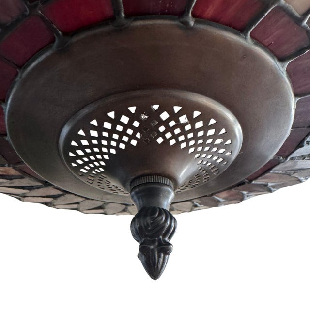 An exquisite Tiffany-style stained glass chandelier featuring richly colored glass panels in warm amber, rose, and soft...