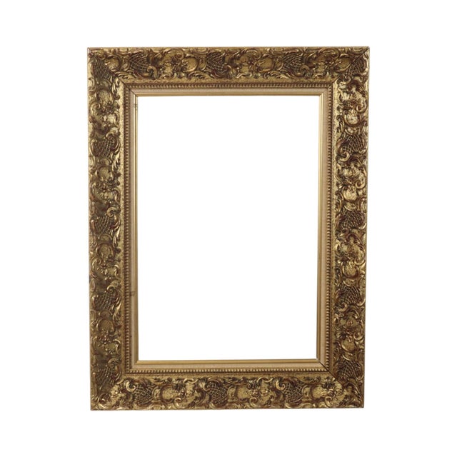 A classic vintage gold-tone frame featuring floral motifs and acanthus ornamentation—fully in the Rococo style—dating from...