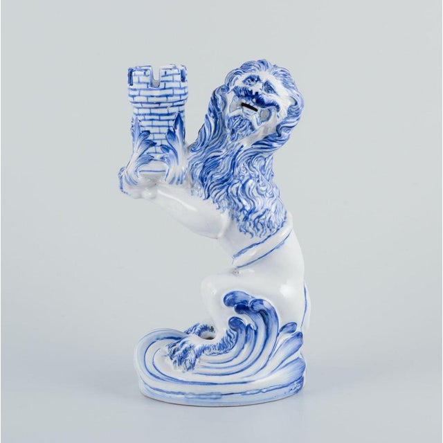 Emile Gallé for Nancy, St Clement. A pair of early and large blue and white faience candle holders modelled as a seated...