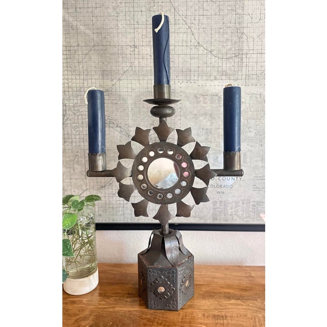 Impressive mid-century hand-forged Mexican tin three-arm candelabra featuring a dramatic sunburst design with a central...