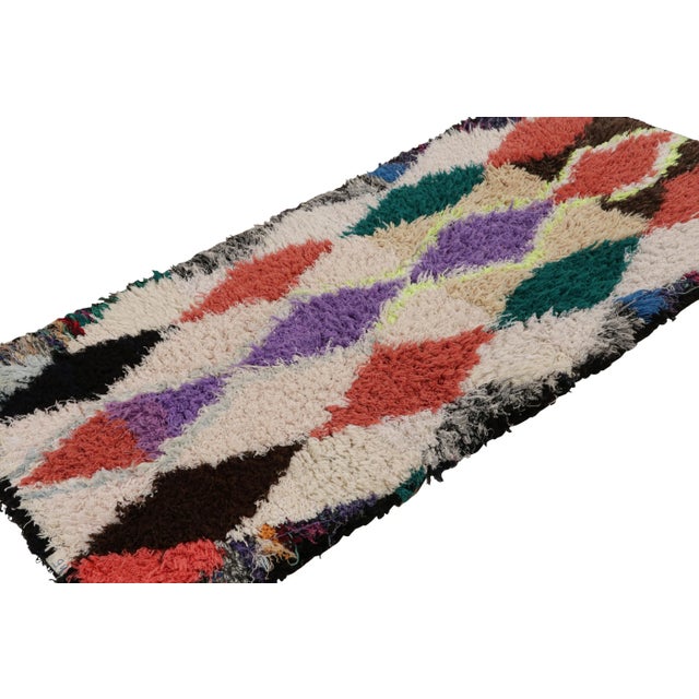 Hand-knotted in wool, circa 1950-1960, this 3x6 vintage Moroccan runner rug is believed to hail from the Azilal tribe. On...