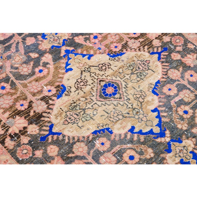 Beautiful vintage Persian distressed hand-knotted wool rug with a blue color field. This piece has a beige frame and...