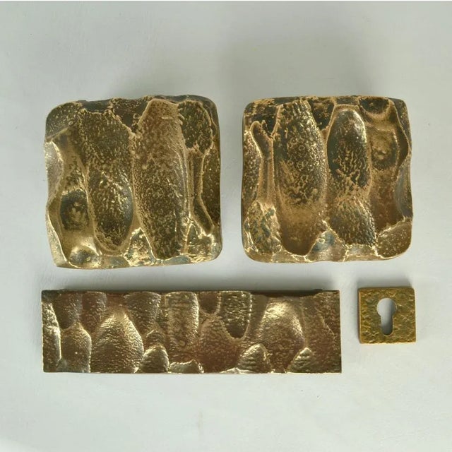Two square cast bronze door handle, letter box and key holder with surface with strong relief like the ripples in the...