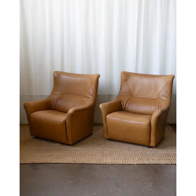 These spacious vintage Swiss leather lounge chairs from the 1970s are all about easy comfort and clean design. Wrapped in...